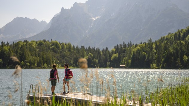 Auf dem Steg am Lautersee mit Blick auf Karwendelberge. Ein besonders idyllischer Badesee in den Bergen von Bayern. , © Alpenwelt Karwendel | Philipp Gülland