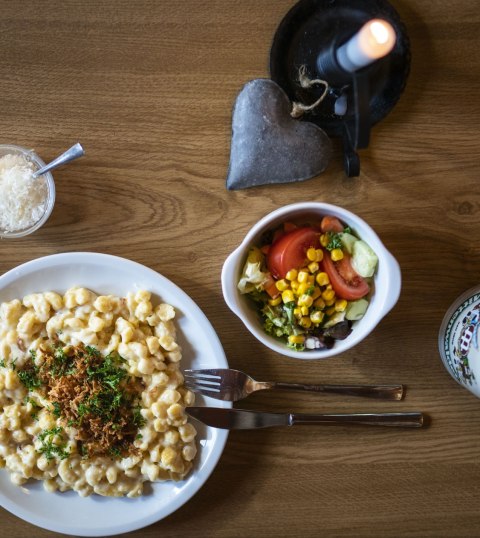 Gedeckter Tisch mit Käsespätzle von der Brunnsteinhütte über Mittenwald, © Alpenwelt Karwendel | Dietmar Denger