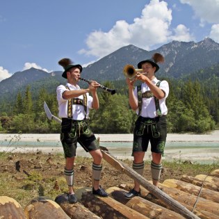 Tyisch bayerische Klänge in Tracht an der Wallgauer Floßbühne, © Alpenwelt Karwendel | Gemeinde Wallgau