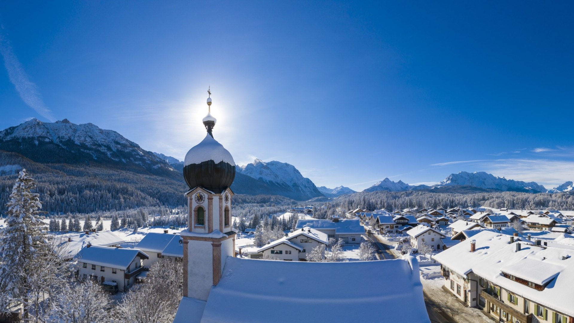 Winter in Krün - church tower with mountain panorama from Seinskopf to Waxensteine., © Alpenwelt Karwendel | Kriner & Weiermann