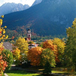 Die Puit mit Weiher im Herbst, Blick auf Kirche St. Peter & Paul mit Karwendel, © Alpenwelt Karwendel | Hubert Hornsteiner