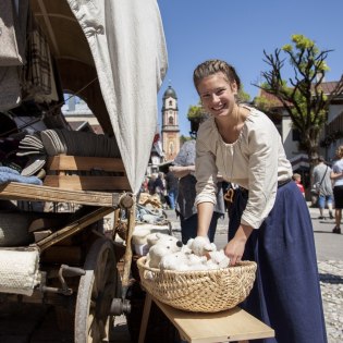 Junge Frau an ihrem Verkaufstand, © Alpenwelt Karwendel | Hubert Hornsteiner Junge Frau an ihrem Verkaufstand, © Alpenwelt Karwendel | Hubert Hornsteiner