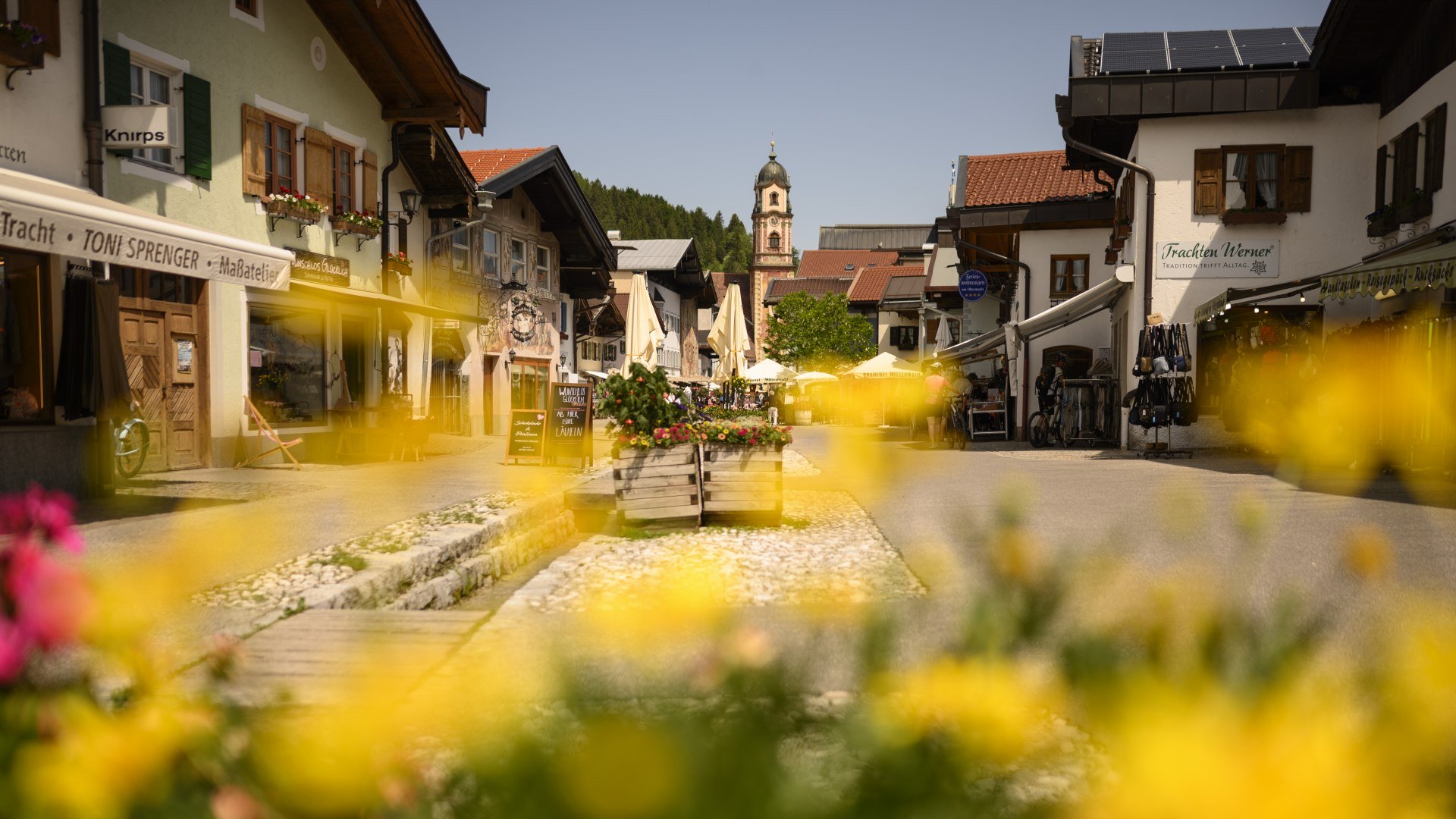 Mittenwald pedestrian zone at the Obermarkt with the typical rows of houses and the picturesque church tower, © Alpenwelt Karwendel | Philipp Gülland