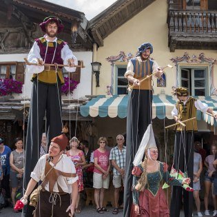 Die Stelzengeher "Hochhaxatn" gehen durch den Obermarkt, © Alpenwelt Karwendel | Wera Tuma