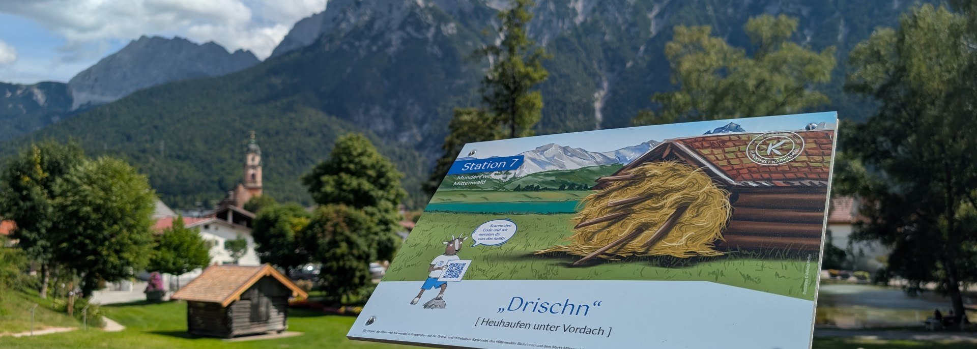 Schild am Mittenwalder Mundartweg, Werdenfelser Dialekt hören