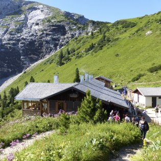 Das Schachenhaus mit Terrasse und Wanderer , © Alpenwelt Karwendel | Sandra Hibler