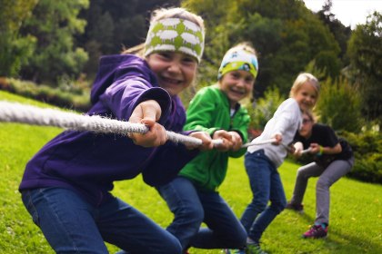 Kinde beim Tauziehen im Kurpark Puit, © Alpenwelt Karwendel | Angelika Warmuth