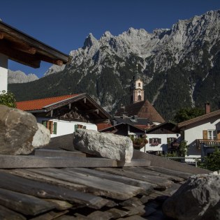 Traditionelles Holzschindeldach im Mittenwalder Ortsteil Gries mit Kirche St. Peter und Paul und Karwendel , © Alpenwelt Karwendel | Rudolf Pohmann