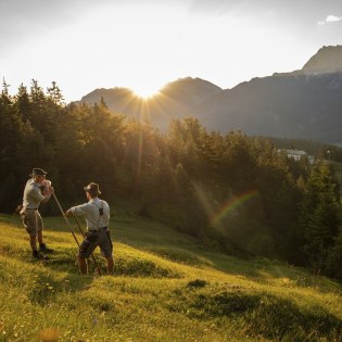 Traditional mowing with the scythe, called meadow mowing. Here on the Kranzberg near Mittenwald. In the background Wörner and Soiernberge., © Alpenwelt Karwendel | Philipp Gülland