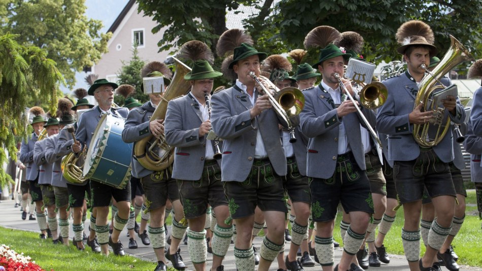 Die Mittenwalder Musikkapelle bei einem sommerlichen Umzug. Blasmusik mit Trommlerzug in Trachten. , © Alpenwelt Karwendel | Hubert Hornsteiner