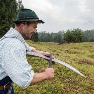 Alois Kramer beim Wetzen der Sense, © Molkerei Berchtesgadener Land