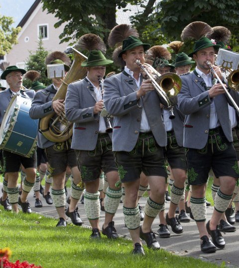 Die Mittenwalder Musikkapelle bei einem sommerlichen Umzug. Blasmusik mit Trommlerzug in Trachten. , © Alpenwelt Karwendel | Hubert Hornsteiner