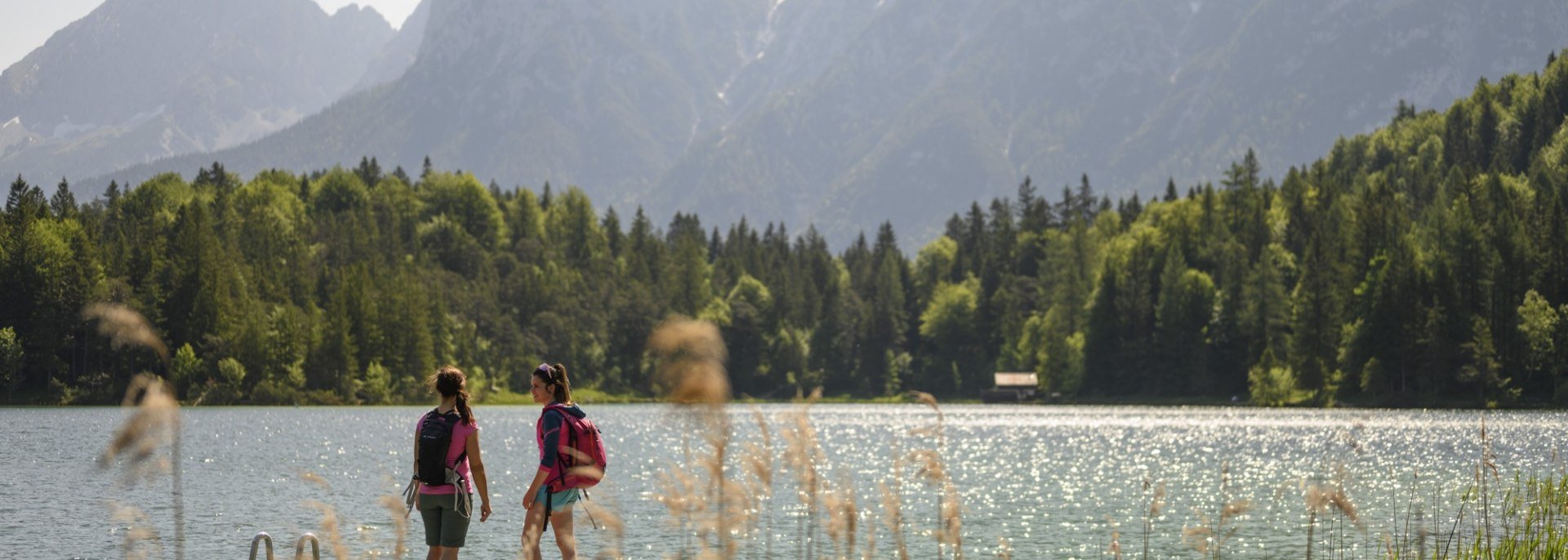 On the jetty at the Lautersee with a view of Karwendel mountains. A particularly idyllic swimming lake in the mountains of Bavaria., © Alpenwelt Karwendel | Philipp Gülland
