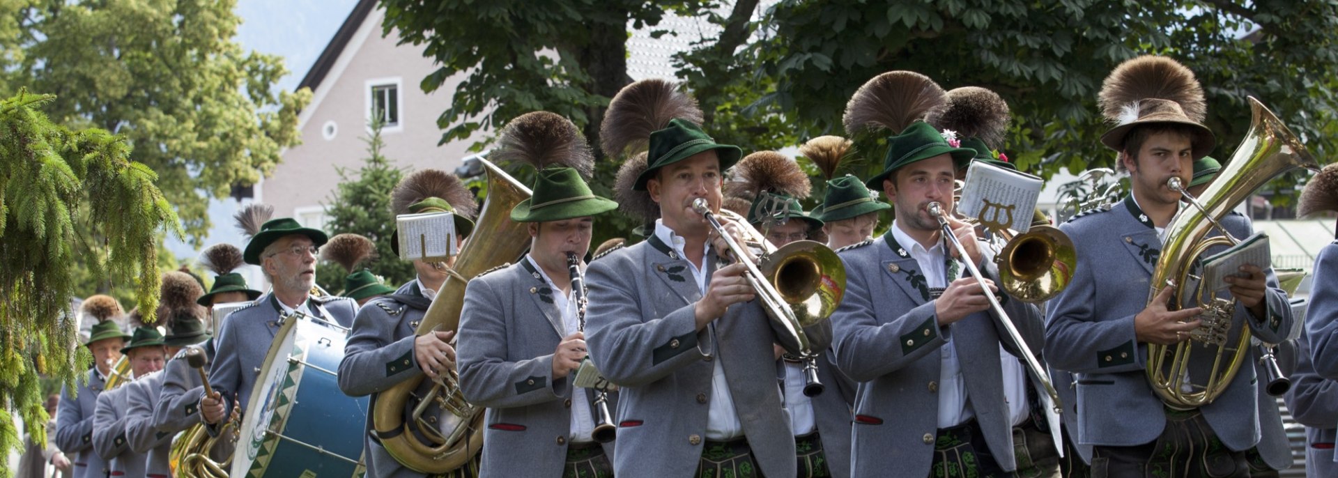 Die Mittenwalder Musikkapelle bei einem sommerlichen Umzug. Blasmusik mit Trommlerzug in Trachten. , © Alpenwelt Karwendel | Hubert Hornsteiner