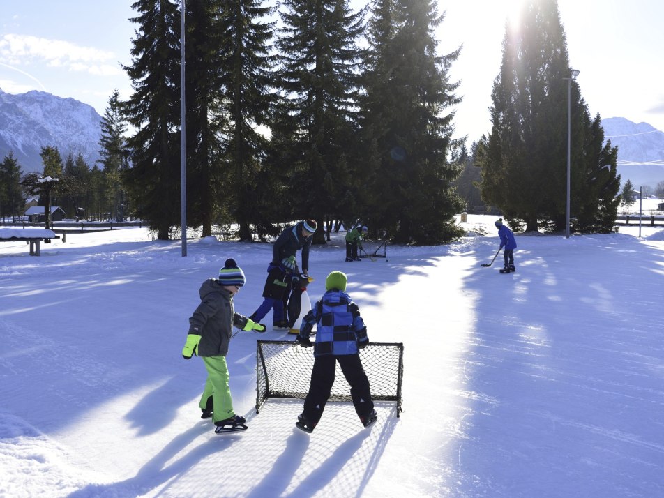 Schlittschuhlaufen und Eishockey spielen auf dem Natur-Eisplatz in Krün Winter, © Alpenwelt Karwendel|Stefan Eisend