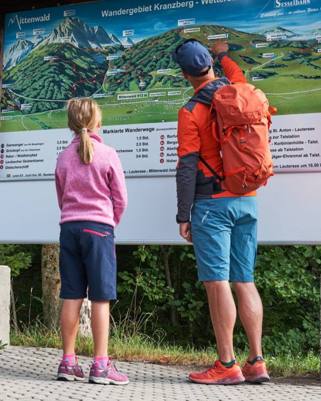 Eine Familie vor der Wegetafel im Wanderparadis Kranzberg bei Mittenwald , © Alpenwelt Karwendel | Anton Brey 