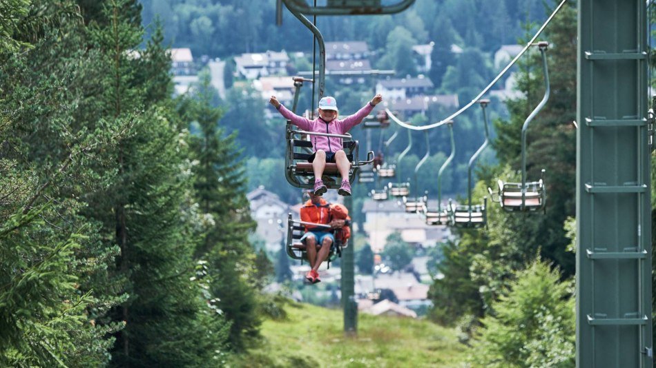 Der Kranzbergsessellift bei Mittenwald mit freudigen Fahrgästen, © Alpenwelt Karwendel | Anton Brey Der Kranzbergsessellift bei Mittenwald mit freudigen Fahrgästen, © Alpenwelt Karwendel | Anton Brey