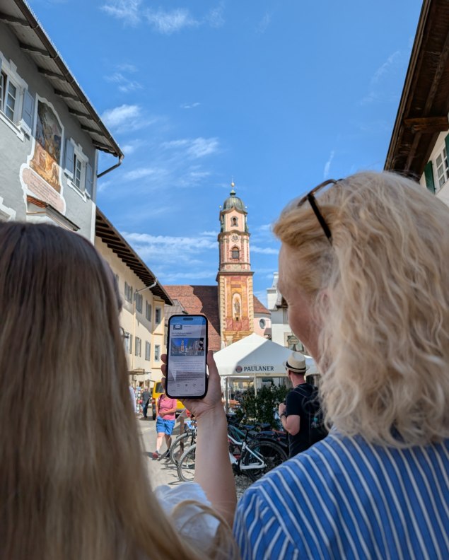 Innovative App mit Blick auf den Kirchturm Mittenwalds