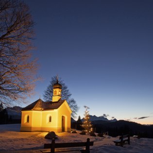 Die Kapelle Maria Rast bei Krün auf en winterlichen Buckelwiesen in Abenddämmerung , © Alpenwelt Karwendel | Hubert Hornsteiner