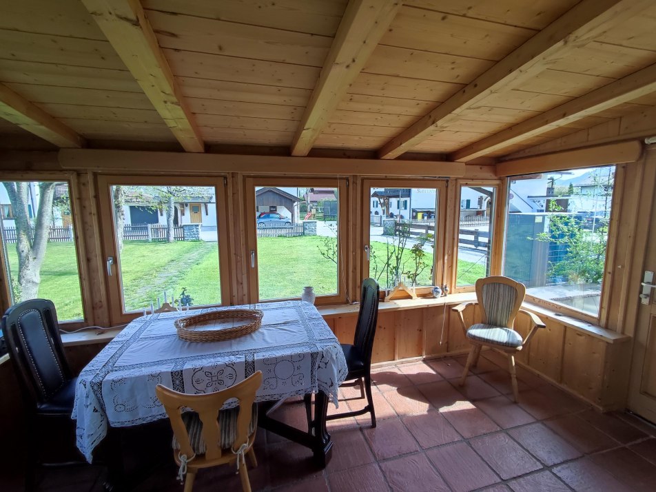 Wintergarten mit Esstisch und Zugang zur Terrasse