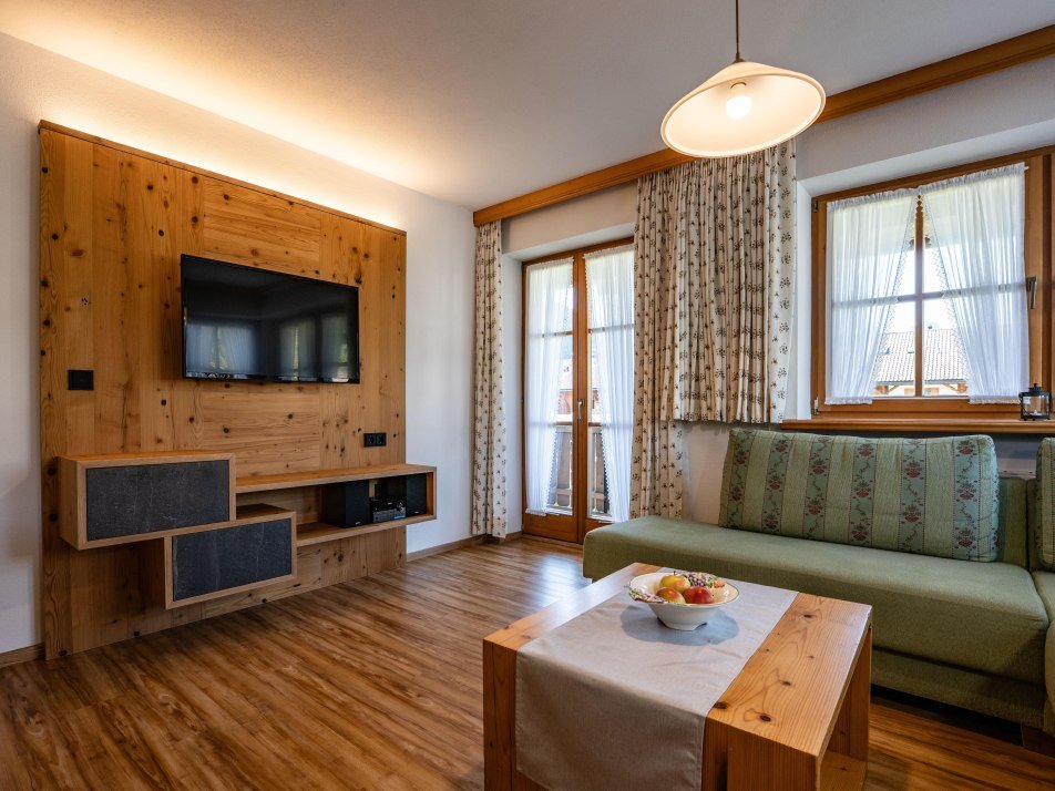 wohnen mit TV auf beleuchteter Massivholzwand