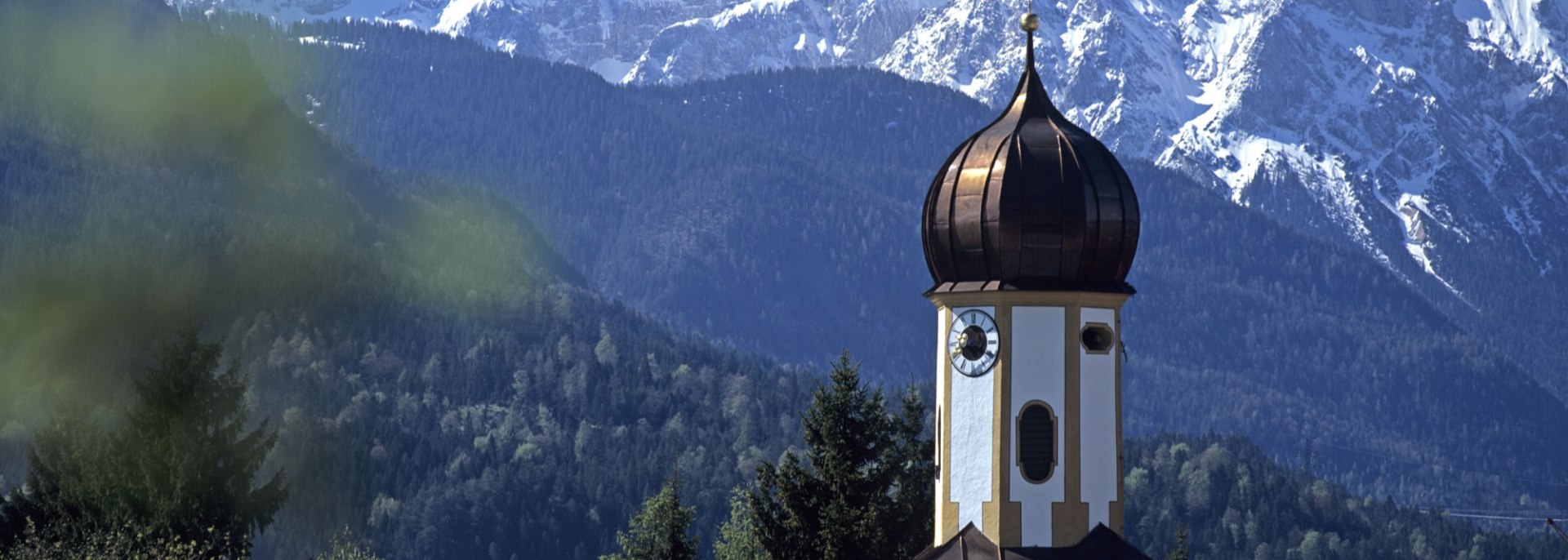 Verschneite Berge des Karwendel, im Vordergrund die Wallgauer Kirche, © Alpenwelt Karwendel | Wenzel Fischer 