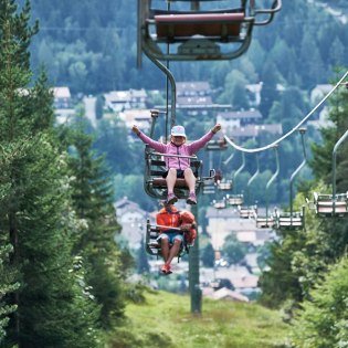 Der Kranzbergsessellift bei Mittenwald mit freudigen Fahrgästen, © Alpenwelt Karwendel | Anton Brey 