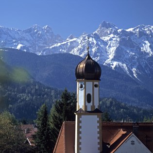 Verschneite Berge des Karwendel, im Vordergrund die Wallgauer Kirche, © Alpenwelt Karwendel | Wenzel Fischer 
