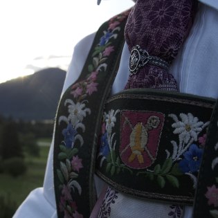 A young costumer with silk scarf and embroidered trousers, with the Krüner local coat of arms., © Alpenwelt Karwendel | Lena Staltmair