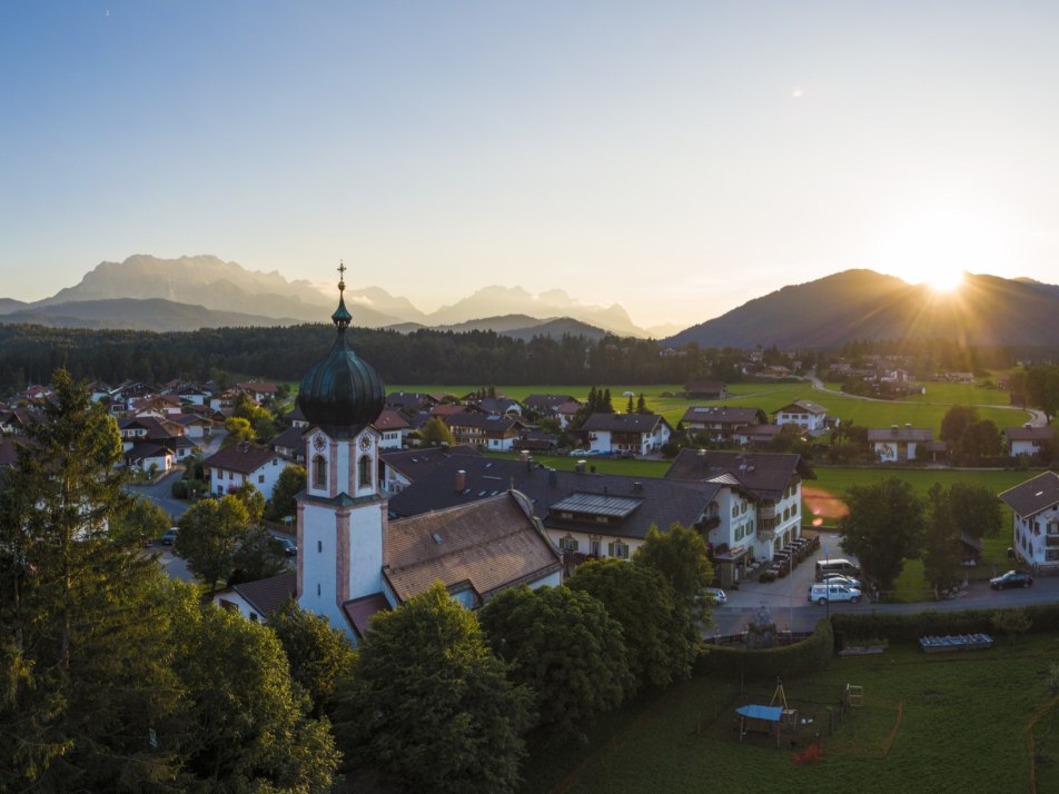 Sonnenuntergang über Krün und der Kirche St. Sebastian, © Alpenwelt Karwendel | Wolfgang Ehn