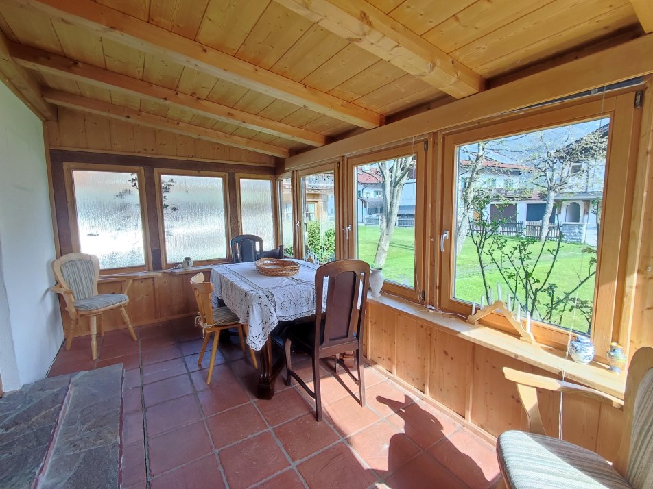 Wintergarten mit Esstisch und Zugang zur Terrasse