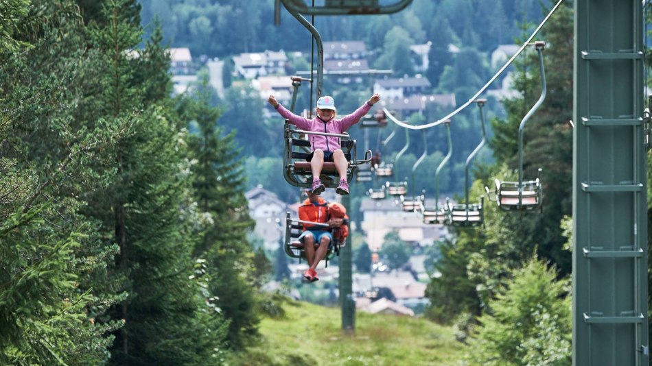 Der Kranzbergsessellift bei Mittenwald mit freudigen Fahrgästen, © Alpenwelt Karwendel | Anton Brey 