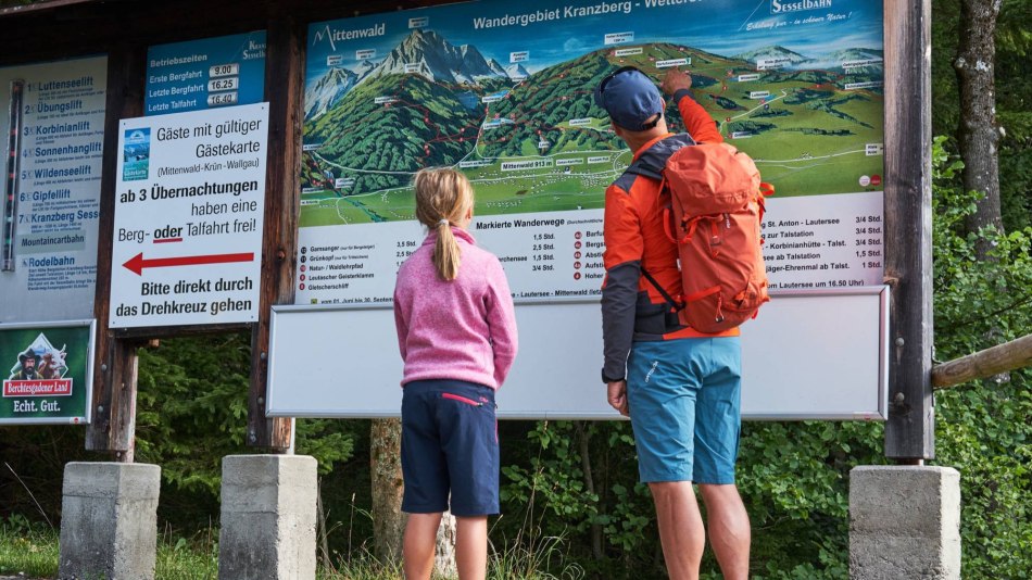 A family in front of the trail board in the hikingarea of Kranzberg near Mittenwald , © Alpenwelt Karwendel | Anton Brey 