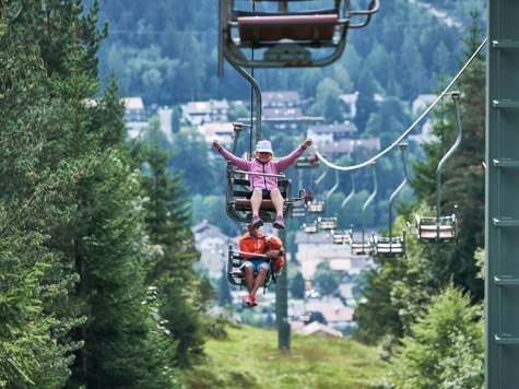 Der Kranzbergsessellift bei Mittenwald mit freudigen Fahrgästen, © Alpenwelt Karwendel | Anton Brey 