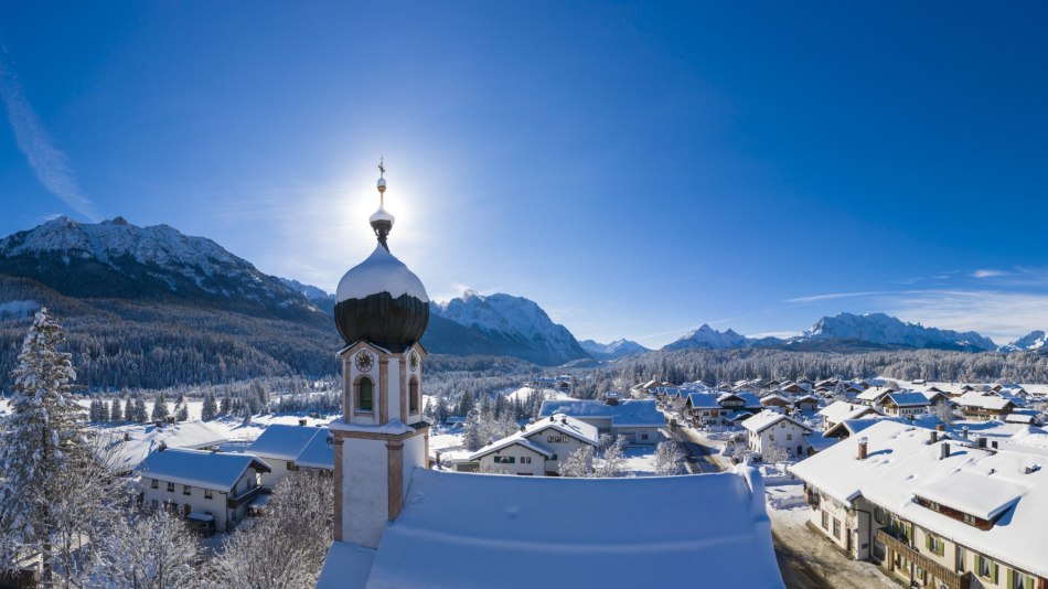 Winter in Krün - church tower with mountain panorama from Seinskopf to Waxensteine., © Alpenwelt Karwendel | Kriner & Weiermann