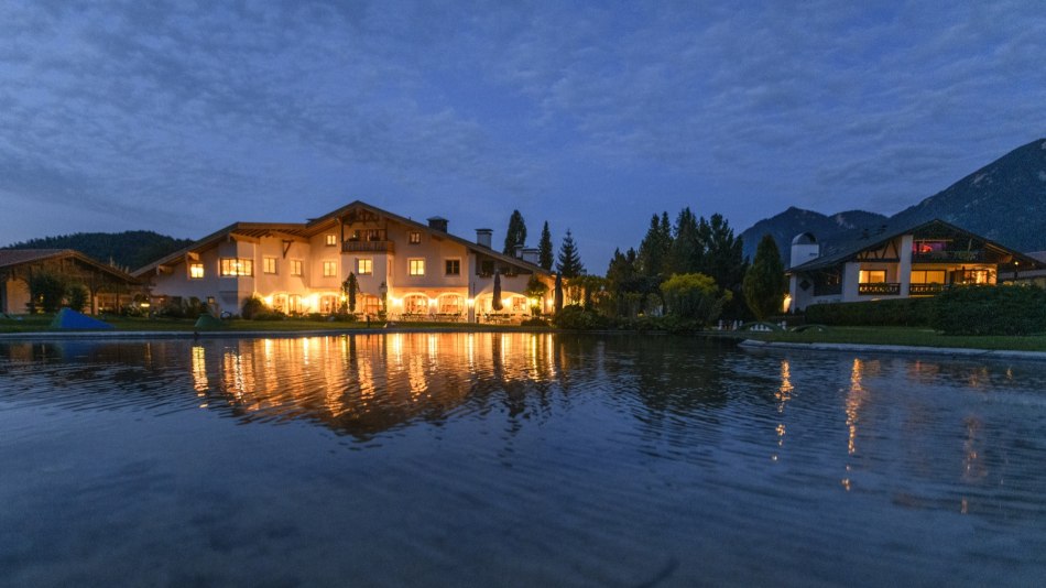 Frontansicht bei Abenddämmerung des Haus des Gastes, © Alpenwelt Karwendel | Wolfgang Ehn