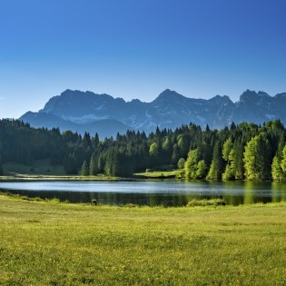 Lush shades of green at Schmalensee near Mittenwald with a view of Karwendel mountains, © Alpenwelt Karwendel | Paul Wolf